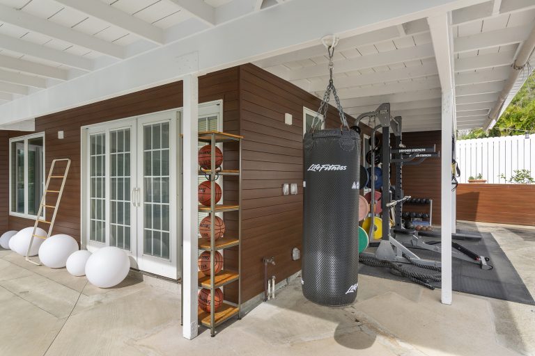 Outside home gym in front of residential home with metal plank siding