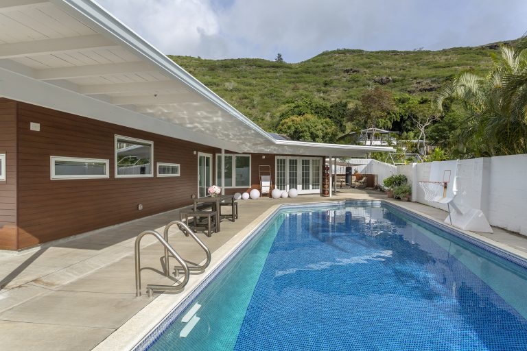 Residential home with plank metal siding and pool with basketball hoop