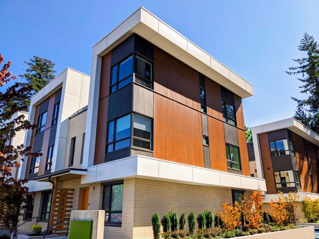 A building with three floors features Al13’s siding. There is a green sign outside of the building.