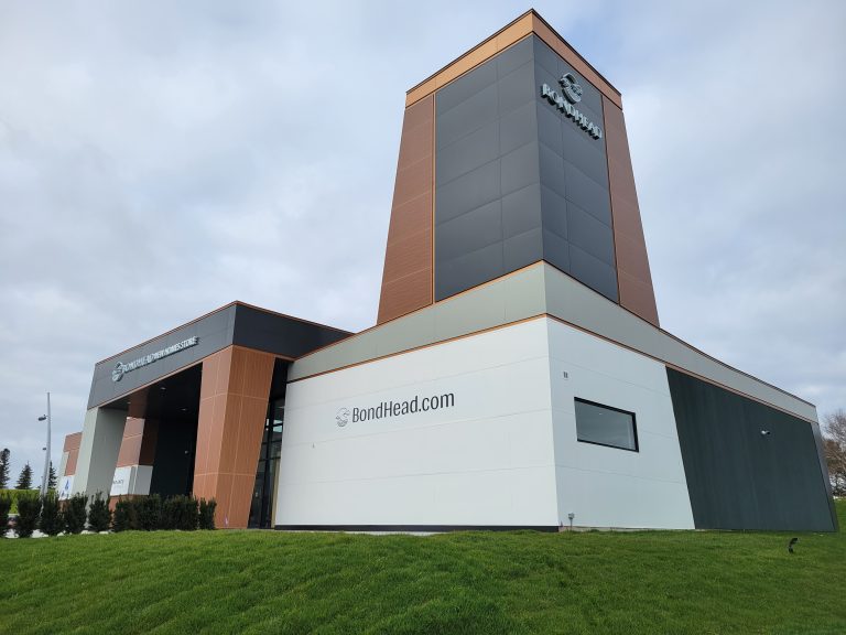 Commercial building with metal panel siding with green grass in front