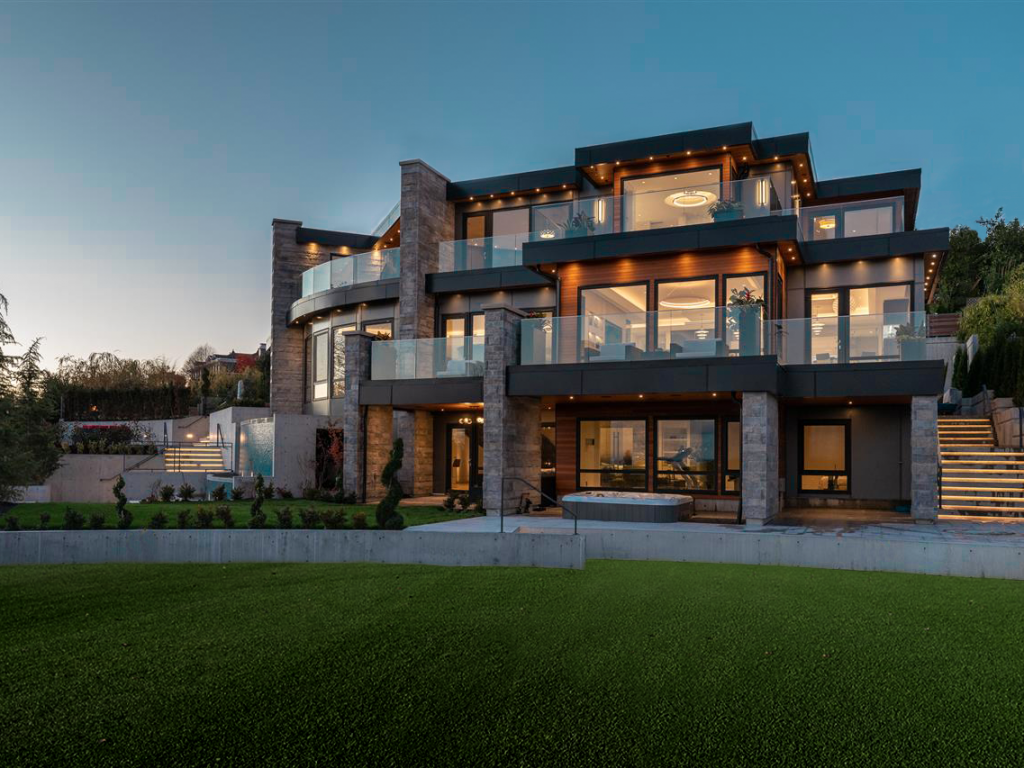 Residential house with black ACM siding, brick and glass. There is grass in front of the house.