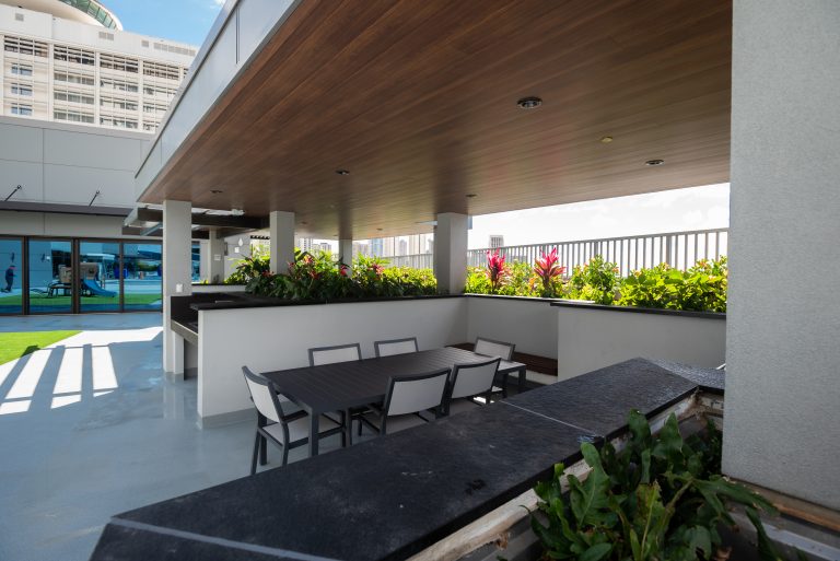 External area of a multi family building with a table with 6 seats and wood grain soffit